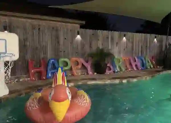 Night pool scene with HAPPY BIRTHDAY letters at Cypress River Oasis